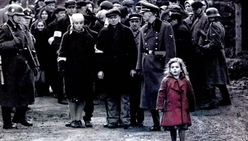 Dziewczynka w czerwonym płaszczu na tle sceny z filmu "Lista Schindlera" z obsadą.