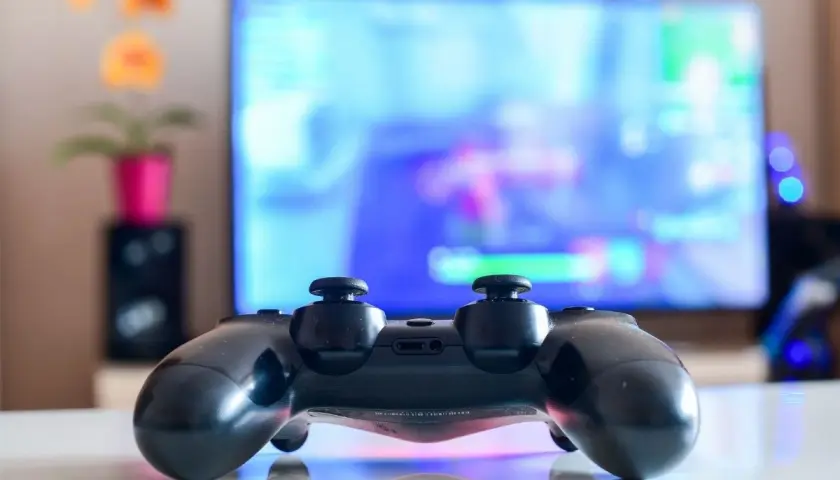 Czarny pad DualShock 4 na białym blacie, gotowy do gry na PC. Dowiedz się, jak podłączyć pada PS4 do PC, by cieszyć się grami na większym ekranie.