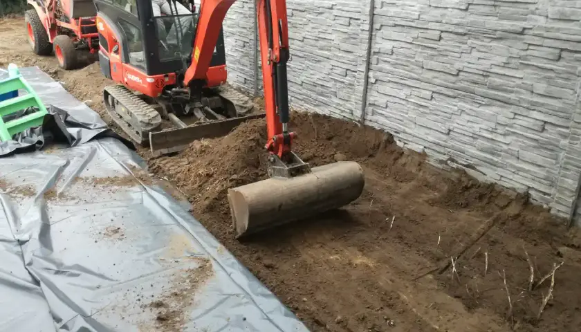 Koparka z walcem przygotowuje teren. To idealny sposób, czym wyrownac ziemie pod budowę lub ogród.