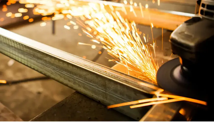 Un disco da taglio genera scintille mentre taglia un profilo metallico. Ecco come tagliare alluminio con precisione.