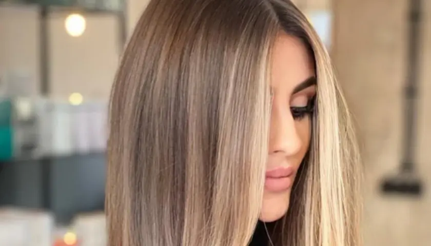 Kobieta z pięknymi, długimi, **front blond** włosami, delikatnie opadającymi na twarz.