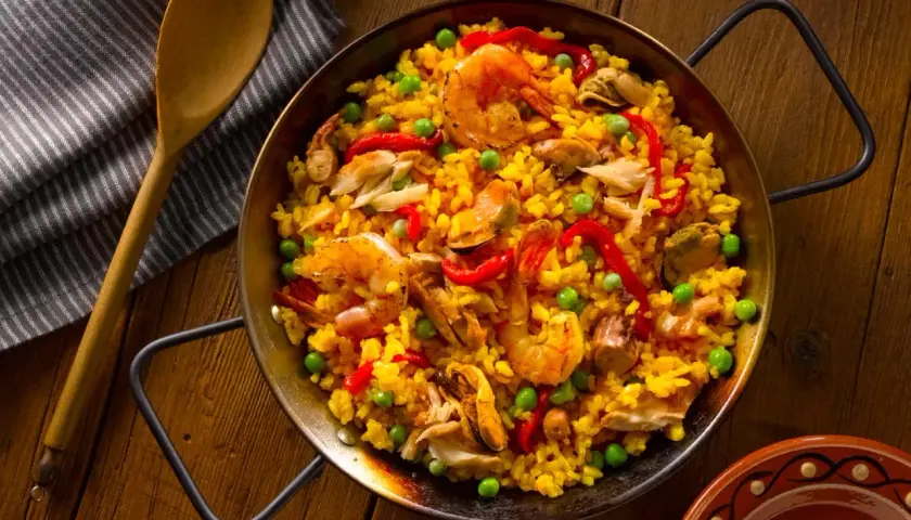 Paella de mariscos, un plato vibrante con arroz amarillo, gambas, mejillones y pimientos. ¡Así es como hacer paella!