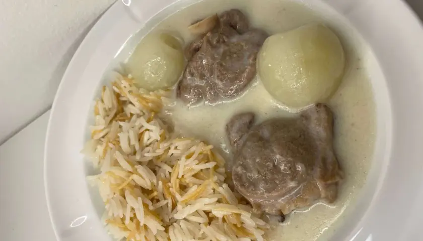 En tallrik med ris, köttbitar i en krämig sås och två hela kokta lökar. En riktig laban emo-måltid!