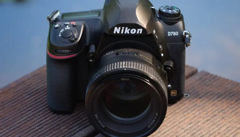 Nikon D780 z obiektywem 85mm f/1.8G na drewnianym pomoście. Aparat gotowy do testów.