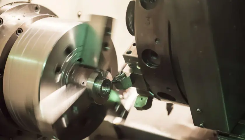 Precyzyjne toczenie CNC metalowego elementu na obracającym się wrzecionie.