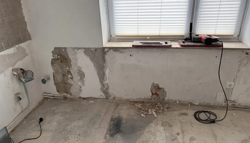 Baustelle mit Werkzeug und freiliegendem Mauerwerk, das auf eine bevorstehende Verkieselung hindeutet.