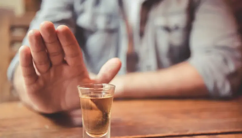Dłoń odpycha kieliszek z alkoholem. Decyzja o abstynencji, jak naltex, jest ważna.