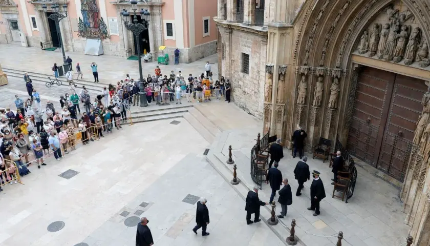 Hombres con togas se reúnen ante la puerta de la Catedral de Valencia, donde se celebra el tribunal de las aguas de Valencia.