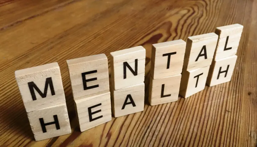 Drewniane klocki z literami tworzą napis "MENTAL HEALTH". To przypomnienie, jak panować nad emocjami i dbać o siebie.
