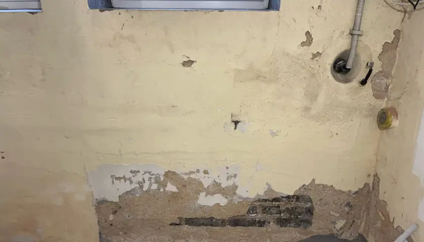 Feuchte Wände im Altbau: Putz bröckelt, Ziegel sind sichtbar. Zeit für eine professionelle Keller trockenlegen Maßnahme.