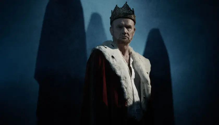 En dyster kung med krona och hermelinskrage. Bilden ger en känsla av makt och förfall, som i pjäsen om vad handlar Macbeth om.