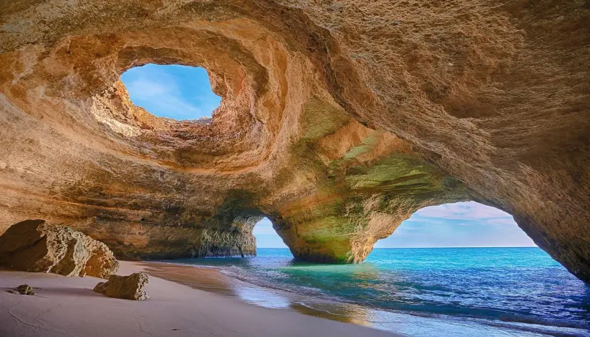 Cueva marina con arco natural y playa de arena. Un lugar perfecto donde viajar en noviembre para disfrutar del sol y el mar.