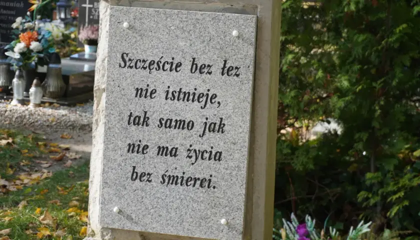 Kamienna płyta z cytatem na cmentarzu, miejsce na urny. "Szczęście bez łez nie istnieje, tak samo jak nie ma życia bez śmierci.