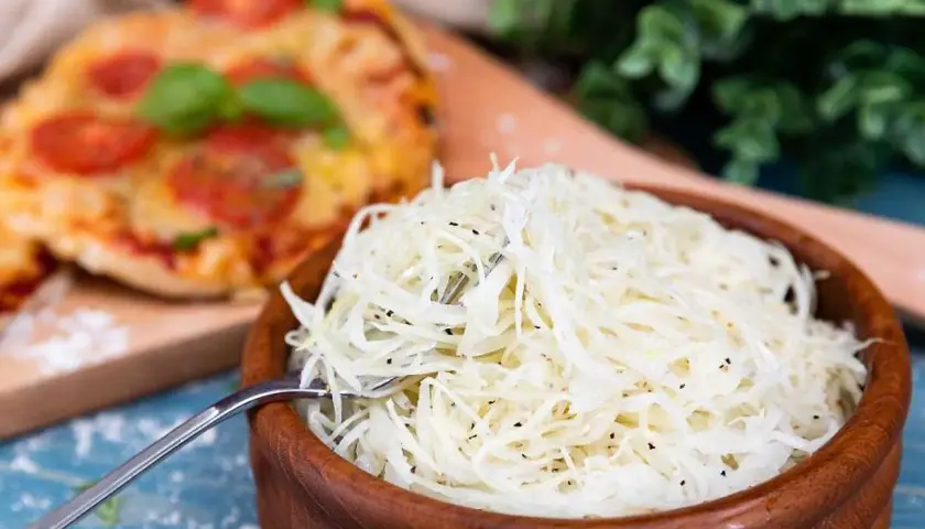 En skål med krispig pizza sallad bredvid en pizza. Perfekt tillbehör!