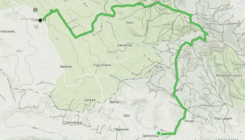 Mapa z zaznaczoną trasą turystyczną przez wzgórza i lasy, z nazwami miejscowości i rezerwatu.