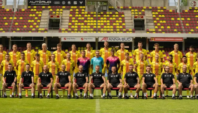 Drużyna Korona Kielce zawodnicy pozują do zdjęcia na tle stadionu.