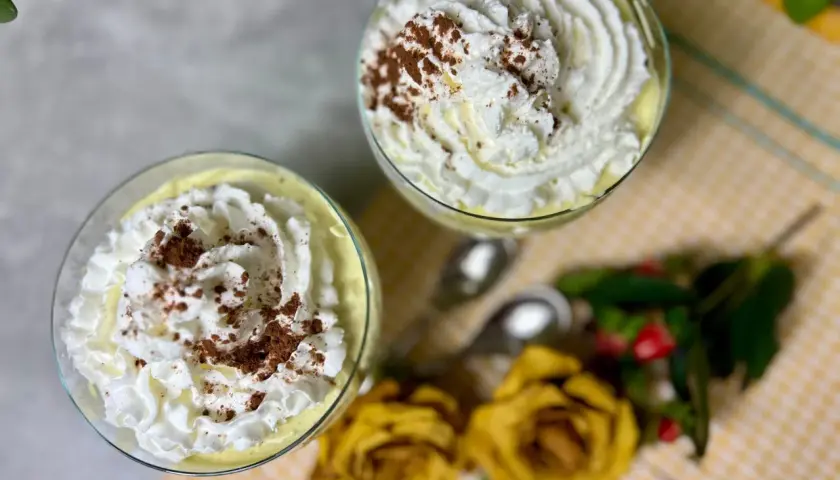 Dwa pucharki z kremem mascarpone, udekorowane bitą śmietaną i kakao. Idealne, gdy zastanawiasz się, co zrobić z mascarpone.