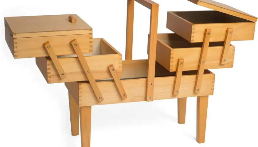 Un costurero madera grande con múltiples compartimentos y patas, ideal para organizar hilos, agujas y otros accesorios de costura.
