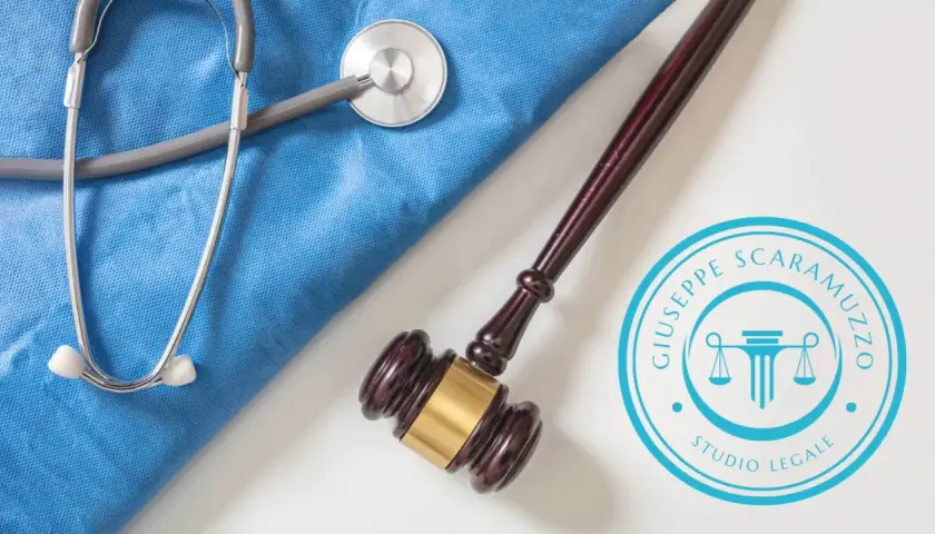 Martelletto da giudice e stetoscopio su camice blu, simboli di giustizia e cura. Studio legale specializzato in casi di malpractice.