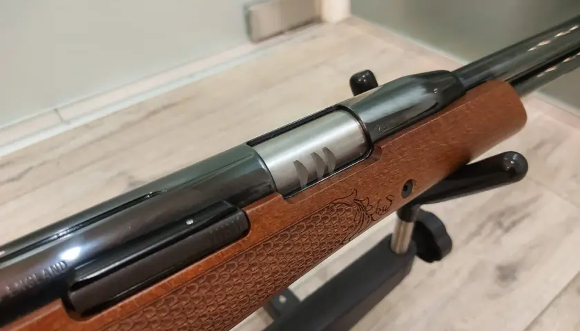 Elegancka wiatrówka Air Arms TX200 z drewnianą osadą, zdobioną grawerem smoka. Precyzja i styl w każdym detalu.