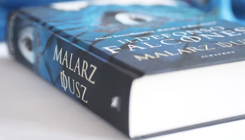 Okładka książki "Malarz dusz" Ildefonso Falconesa w odcieniach niebieskiego.