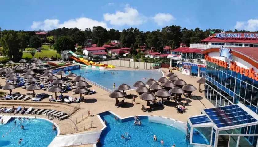 Hotel nad morzem z basenem all inclusive, zjeżdżalniami i mnóstwem leżaków pod parasolami.