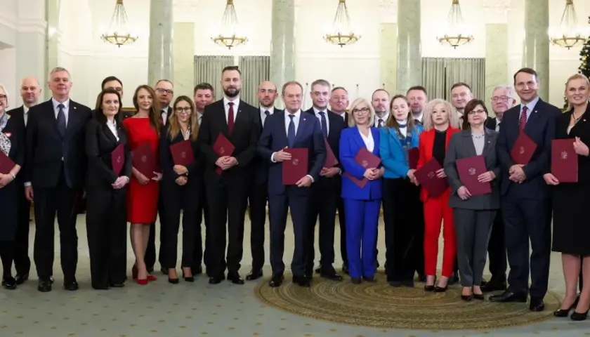 Nowy skład rządu pozuje do zdjęcia z dokumentami.