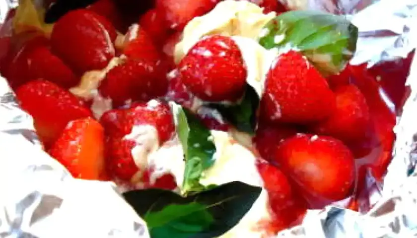 Fraises et crème dans du papier d'aluminium, un délicieux dessert pour barbecue.