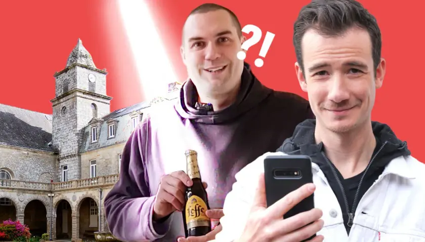 Deux hommes souriants devant un bâtiment historique, l'un tenant une bouteille de Leffe.