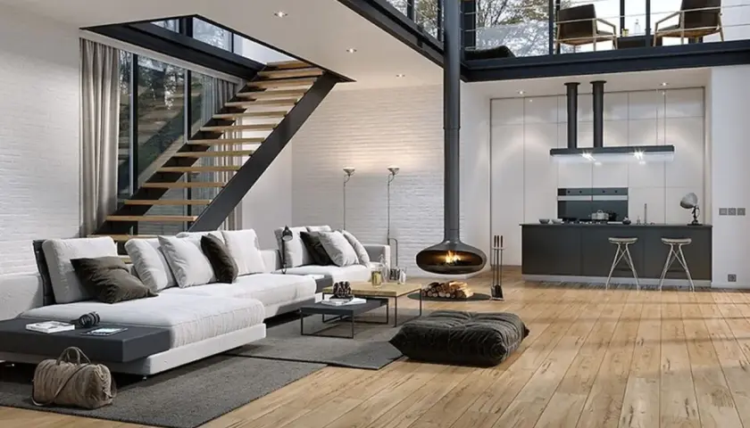 Nowoczesna antresola w domu z widokiem na kuchnię i salon. Drewniane schody prowadzą na górę, gdzie widać dwa fotele.