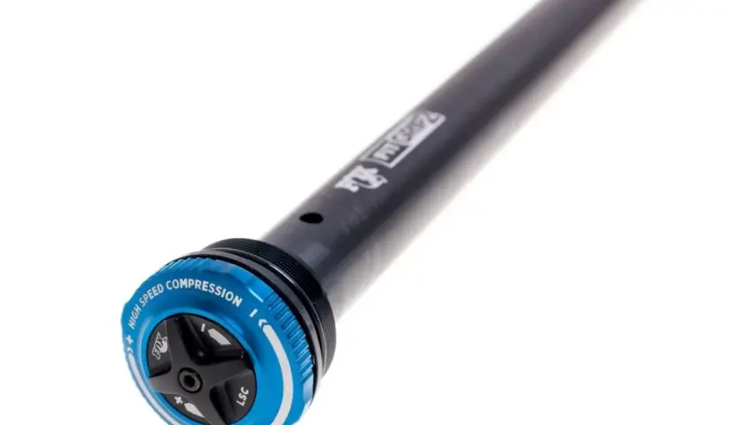 Close-up of a black bicycle suspension stanchion with a blue GRIP2 damper adjustment dial. The dial features "HIGH SPEED COMPRESSION" and "LSC" markings.