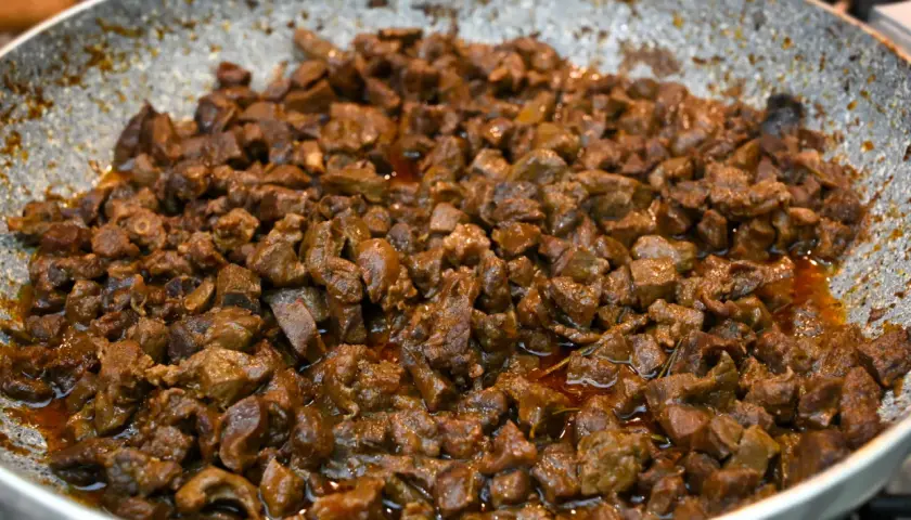 Coratella di agnello saporita, cotta in padella con un sugo ricco e invitante. Un piatto tradizionale pronto per essere gustato.