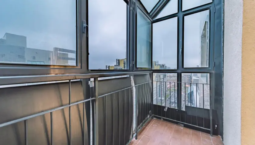 Balcone con vista sulla città, caratterizzato da ampie finestre con infissi neri che incorniciano il panorama urbano.