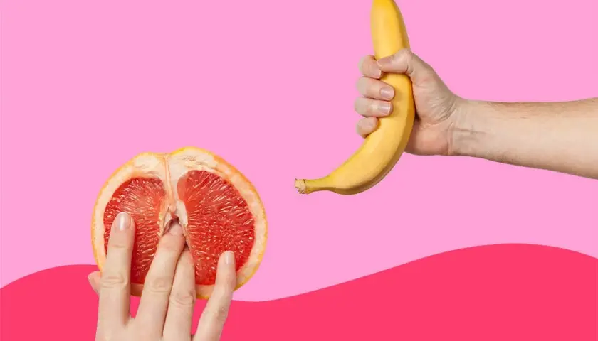 Mani che esplorano un pompelmo tagliato a metà, suggerendo come ci si masturba, mentre una banana è tenuta in un'altra mano.