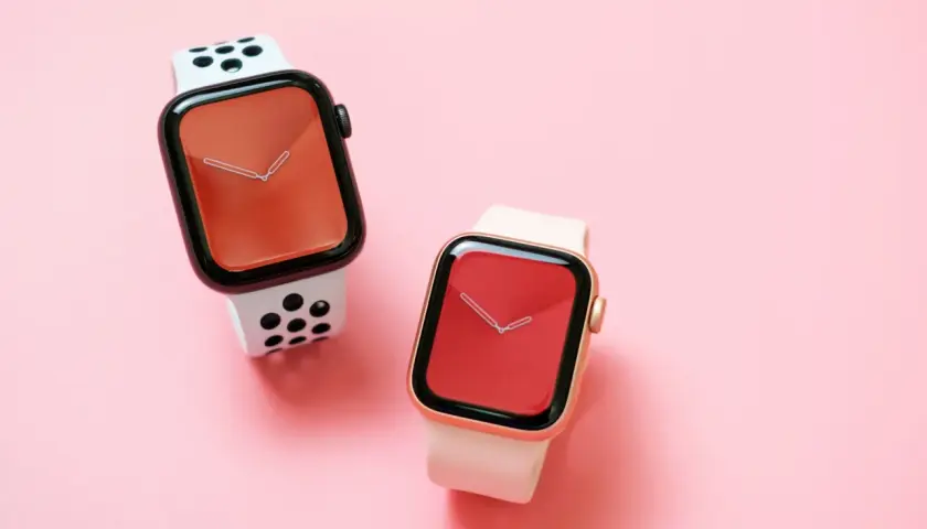 Dwa zegarki Apple Watch na różowym tle. Jeden z białym paskiem w czarne kropki, drugi z jasnoróżowym. Czas na wymiana baterii Apple Watch.