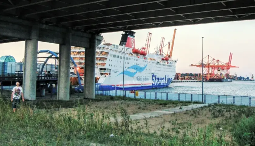 Widok na prom Stena Line w Gdyni, z dwoma mężczyznami na pierwszym planie. W tle portowe dźwigi i inne statki.
