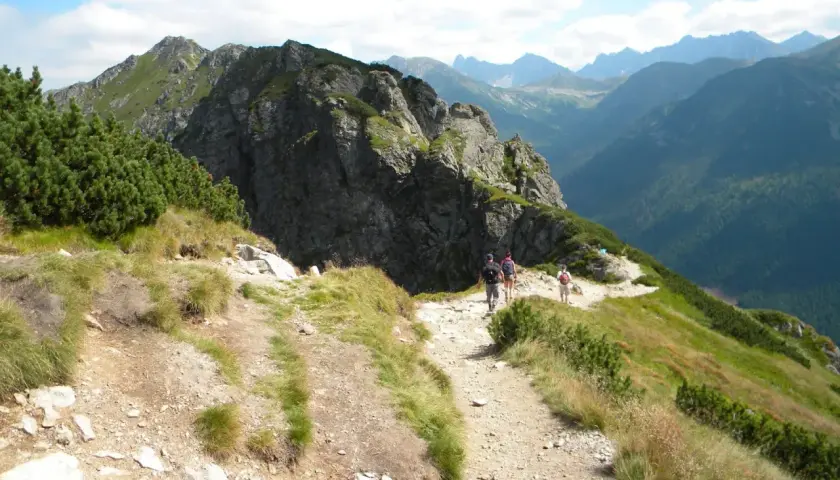 Grupa turystów wędruje malowniczym szlakiem w Tatrach. Widok na góry i doliny, idealne tatry szlaki dla średnio zaawansowanych.