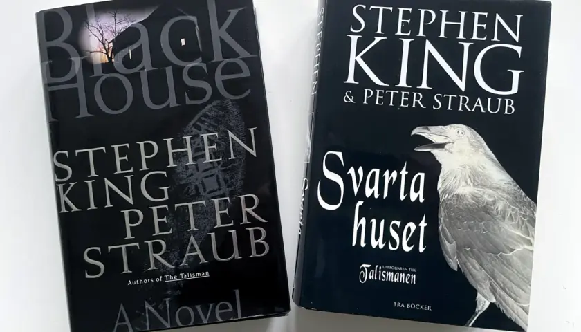 Två Stephen King-böcker: "Black House" och den svenska översättningen "Svarta huset". En mörk atmosfär med en kråka som symboliserar de oskyldiga.
