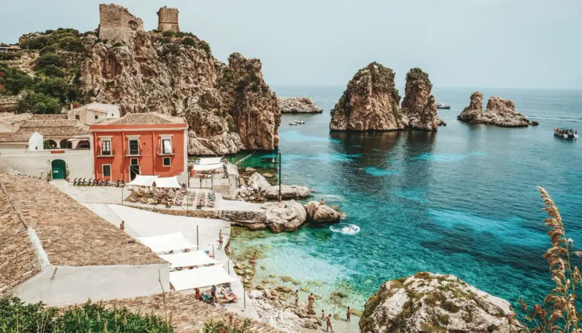 A picturesque cove with turquoise waters, rocky islets, and a charming village, this is a must-see among top places to visit in Sicily.