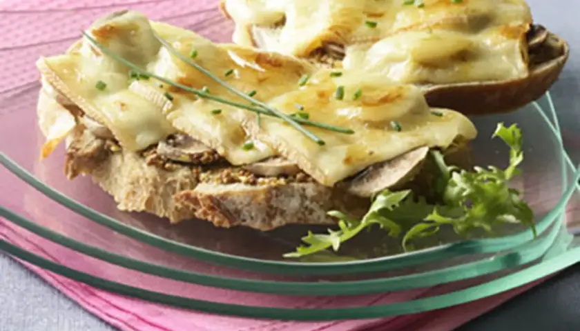 Tartines gourmandes avec une généreuse croute de fromage fondue, garnies de champignons et de ciboulette.