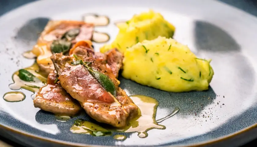 Saltimbocca: Kalbfleisch mit Salbei und Schinken, serviert mit Kartoffelpüree. Ein Klassiker, der zeigt, was Saltimbocca ist.