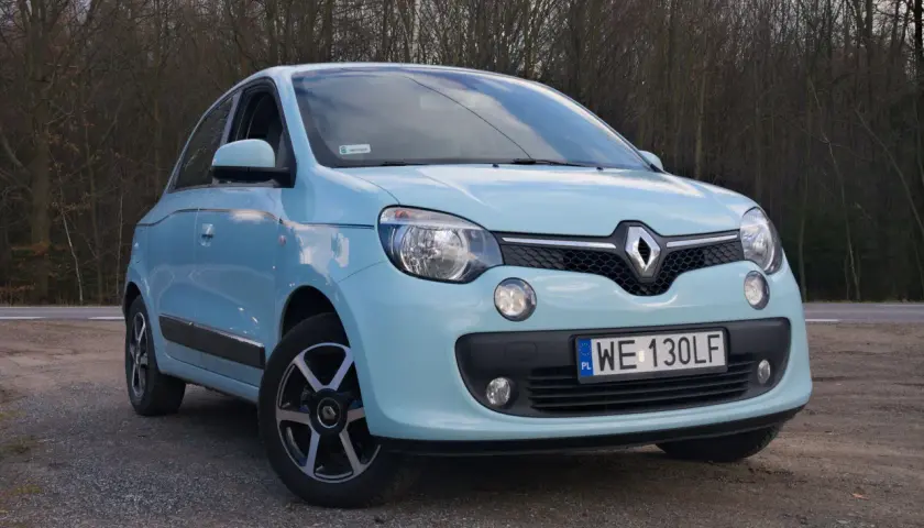 Jasnoniebieskie Renault Twingo na tle drzew. Zastanawiasz się nad jego **renault twingo spalanie**?