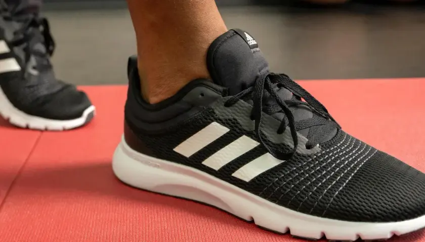 Czarne buty sportowe Adidas z białymi paskami, idealne do biegania. Poznaj różne rodzaje butów sportowych i ich nazwy.
