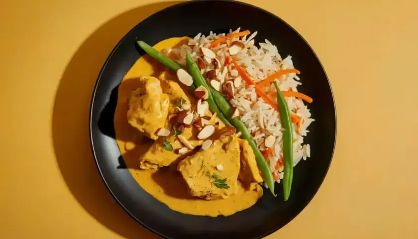 Aksamitny kurczak w sosie curry, podany z ryżem, fasolką szparagową i migdałami. Pyszne danie, które rozpływa się w ustach.