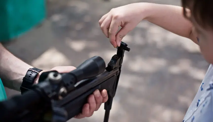 Dziecko uczy się, jak wygląda wiatrówka, manipulując jej mechanizmem.