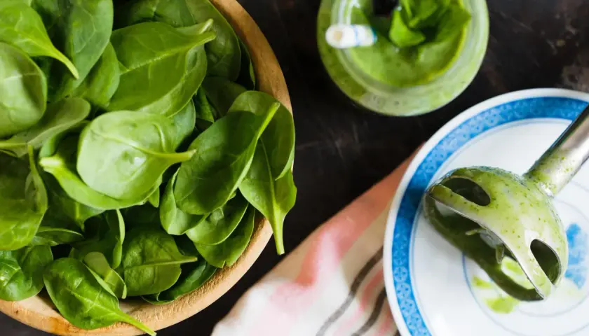 Świeży szpinak w misce, zielony koktajl i blender ręczny. Czy szpinak jest zdrowy? Tak, to superfood!