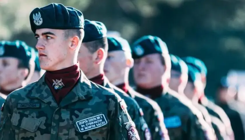 Młodzi żołnierze w mundurach, gotowi do służby. Zastanawiają się, jaki stopień wojskowy po szkole średniej osiągną.