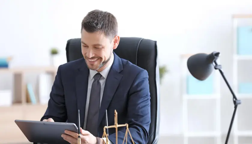 Un notaire souriant consulte une tablette, prêt pour un appel de fonds. La balance de la justice est visible.