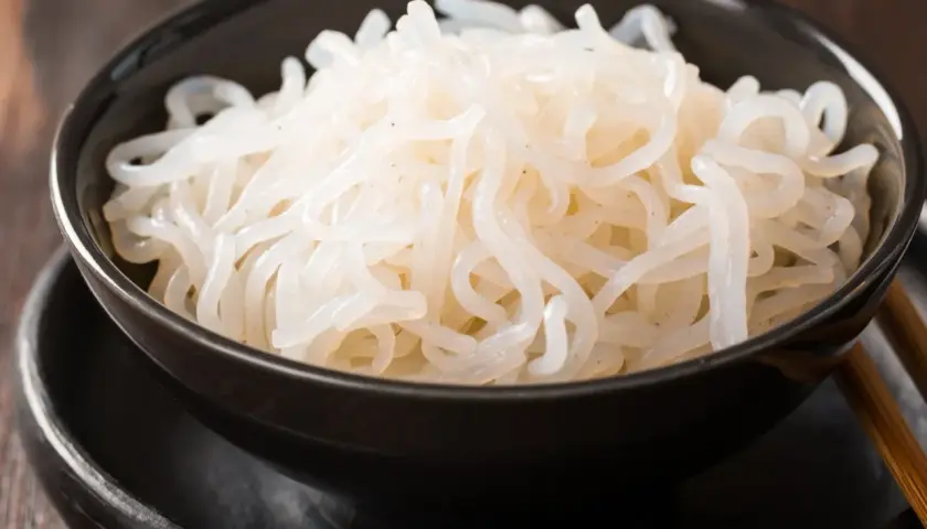 Misternie zwinięty makaron konjac w czarnej misce. To zdrowe i niskokaloryczne danie, które warto wypróbować.