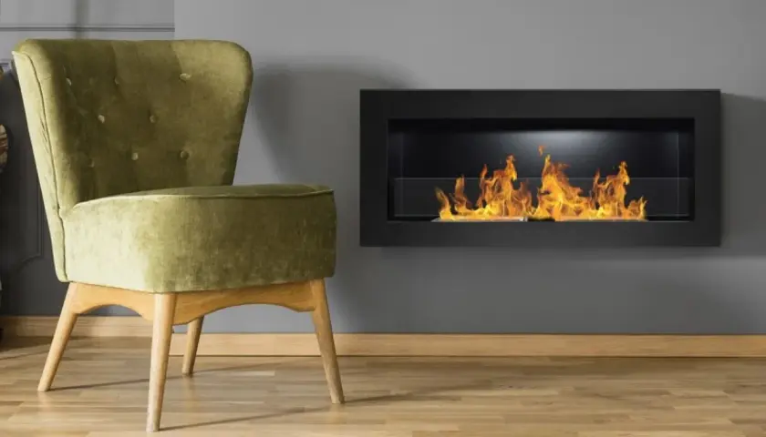 Sillón verde junto a una chimenea moderna con llamas danzantes. El humo de la chimenea crea un ambiente acogedor.